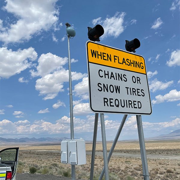 Chains or Snow Tires Required When Lights Are Flashing Sign